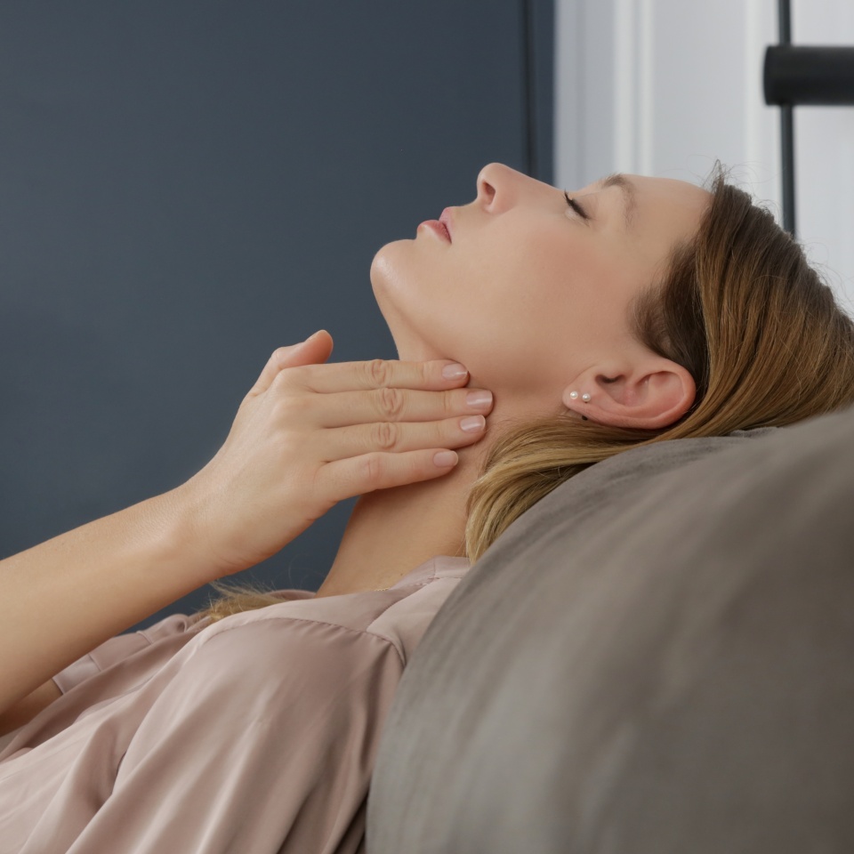 Caucasian woman touching her throat. Sore throat, cold, flu, tonsillitis or thyroid gland problem