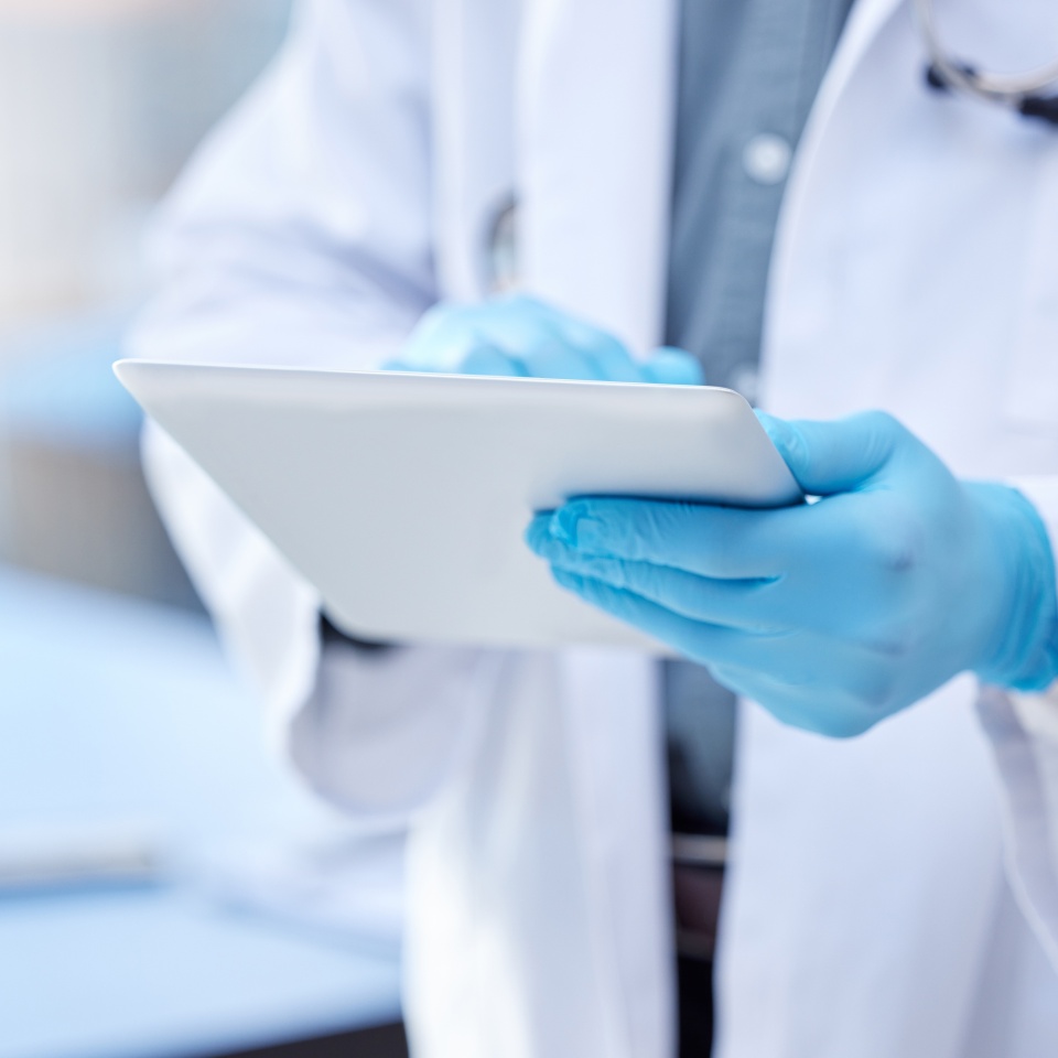 Doctor, hands and gloves with digital tablet for record keeping of patient in hospital with consulting. Healthcare, technology and research with people for innovation in medicine for medical analysis