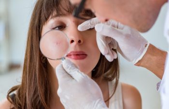 Doctor examining the skin of female patient